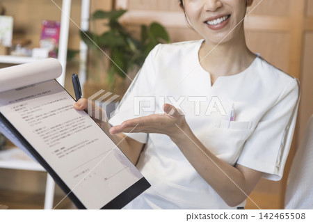 Salon staff explaining the medical questionnaire Salon staff explaining the medical questionnaire 142465508