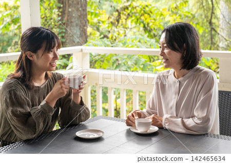 兩個女人在露台上聊天。 兩個女人在露台上聊天。 142465634