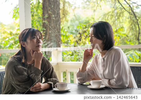 在安靜的咖啡館裡,一位女士傾聽朋友的煩惱。 在安靜的咖啡館裡,一位女士傾聽朋友的煩惱。 142465643