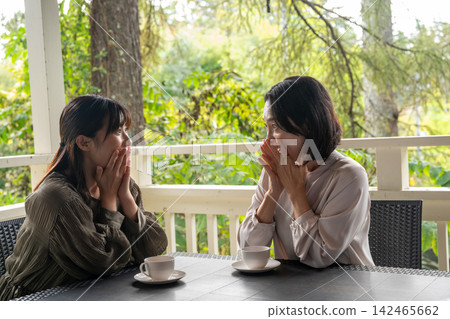 一位女士在露臺上溫柔地安慰她的朋友。 142465662