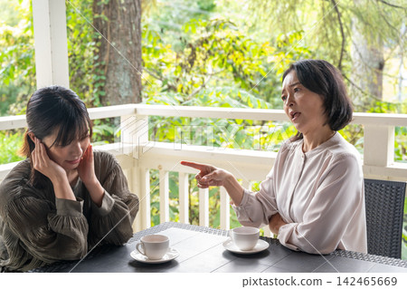 A woman who listens attentively to people's problems in a cafe surrounded by trees. A woman who listens attentively to people's problems in a cafe surrounded by trees. 142465669