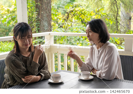 一位在秋日高地咖啡館裡認真傾聽人們煩惱的女士。 一位在秋日高地咖啡館裡認真傾聽人們煩惱的女士。 142465670