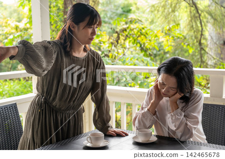 A woman attentively listening to her friend's story in a quiet cafe. A woman attentively listening to her friend's story in a quiet cafe. 142465678