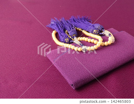Prayer beads and prayer bead case, purple background Prayer beads and prayer bead case, purple background 142465803
