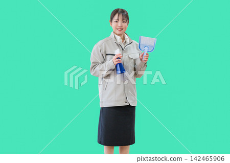一位女清潔工拿著噴霧瓶和簸箕。 142465906
