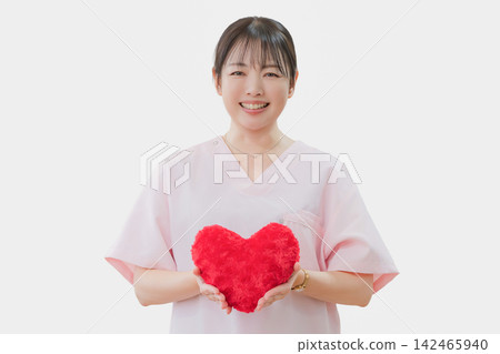 一位女護士手裡拿著一個心型靠墊 一位女護士手裡拿著一個心型靠墊 142465940