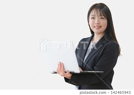 一個穿著西裝的女人拿著筆記本電腦 一個穿著西裝的女人拿著筆記本電腦 142465943