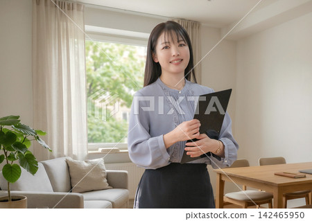 A woman holding a file in the living room A woman holding a file in the living room 142465950