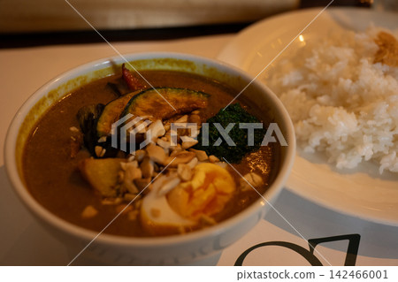 Curry topped with colorful vegetables and nuts Curry topped with colorful vegetables and nuts 142466001