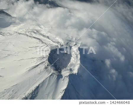 富士山的冬季景色:從飛機上拍攝的白雪皚皚的山峰和雲海。 富士山的冬季景色:從飛機上拍攝的白雪皚皚的山峰和雲海。 142466048