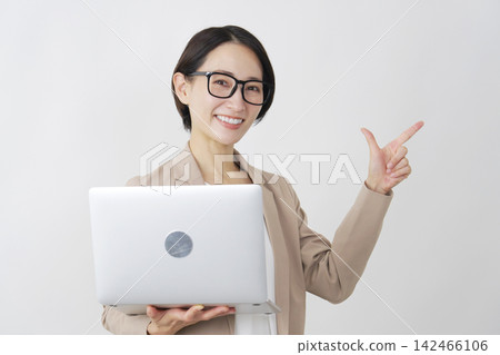 一位女商人用筆記型電腦在白色背景上比劃了一個勾號。 142466106