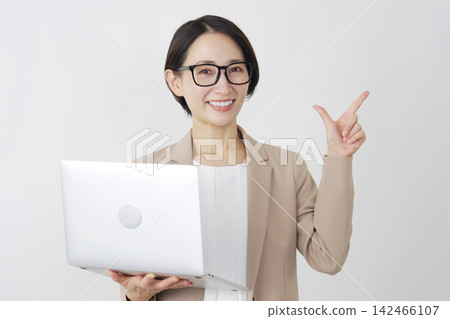 一位女商人用筆記型電腦在白色背景上比劃了一個勾號。 142466107