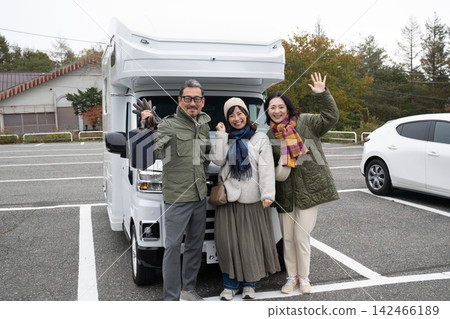Three people set off on a road trip to see the autumn leaves. Three people set off on a road trip to see the autumn leaves. 142466189