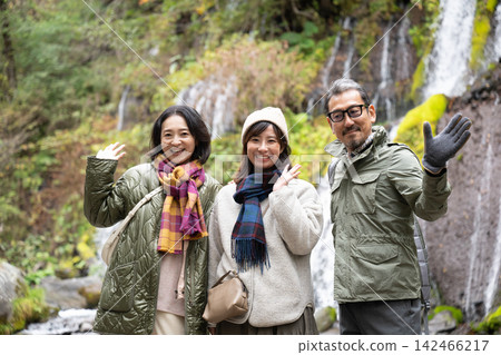 Three friends smiling with the waterfall behind them at Toryu Falls. Three friends smiling with the waterfall behind them at Toryu Falls. 142466217