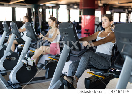 Young woman exercising on exercise bike in gym 142467199