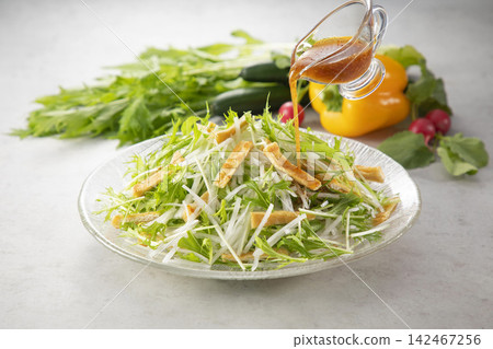 Imagine a salad of daikon radish and mizuna greens with dressing. Imagine a salad of daikon radish and mizuna greens with dressing. 142467256