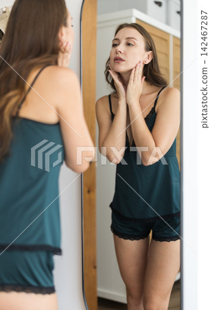 In bedroom girl looking at her reflection in mirror 142467287