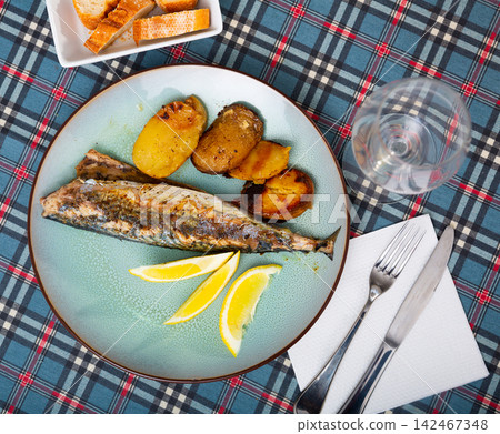Fried mackerel served with baked potatoes on side served nicely on plate Fried mackerel served with baked potatoes on side served nicely on plate 142467348