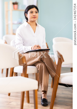 During lecture meeting, female pupil listen to teacher and write down summary in tablet During lecture meeting, female pupil listen to teacher and write down summary in tablet 142467354