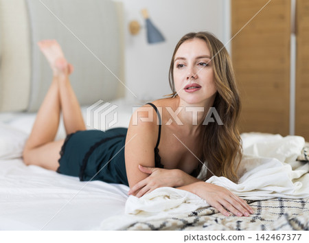 Young woman alone in bedroom, posing and enjoy home time Young woman alone in bedroom, posing and enjoy home time 142467377