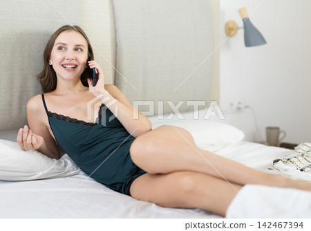 Girl is talking on phone in bedroom space 142467394