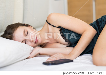 Adult woman sleeping on bed in bedroom Adult woman sleeping on bed in bedroom 142467399