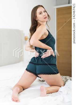 Woman in lingerie posing lying on bed at home Woman in lingerie posing lying on bed at home 142467421