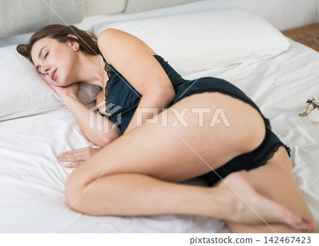 Woman sleeping on bed at home on comfortable pastel linen Woman sleeping on bed at home on comfortable pastel linen 142467423
