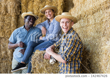 Group of farmers talking at hay storage Group of farmers talking at hay storage 142467426