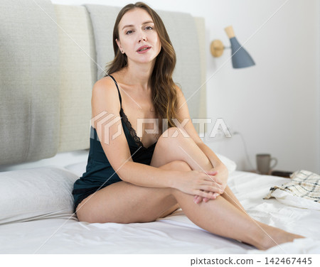 Woman posing in bedroom in home clothes Woman posing in bedroom in home clothes 142467445