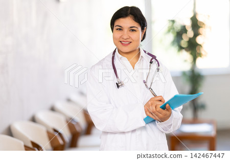 Portrait of friendly female medical receptionist with document Portrait of friendly female medical receptionist with document 142467447