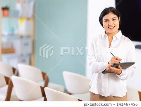 Woman with tablet in lecture hall Woman with tablet in lecture hall 142467456