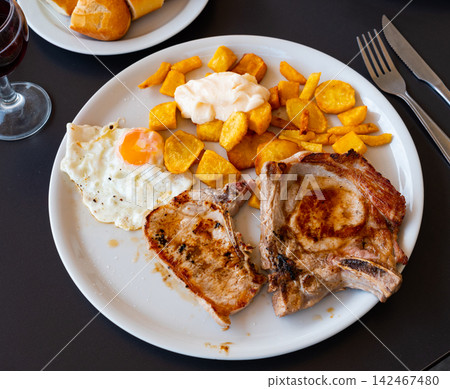Pork chop served with potatoes and egg 142467480
