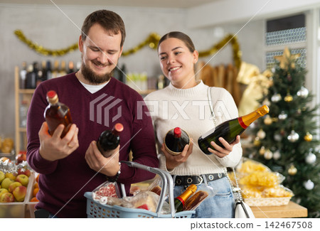 Married couple chooses alcohol in a store with interest Married couple chooses alcohol in a store with interest 142467508