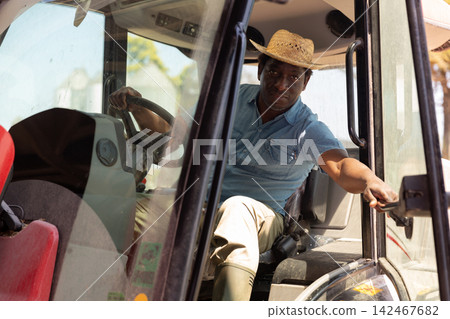 African american man sits the wheel of an agricultural forklift African american man sits the wheel of an agricultural forklift 142467682