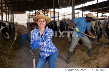 Woman farmer posing at cowshed on farm Woman farmer posing at cowshed on farm 142467683