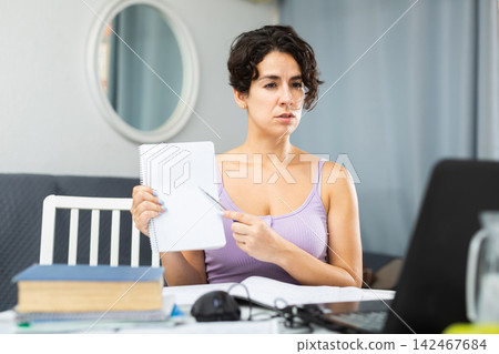 Female student studying at home using laptop and internet Female student studying at home using laptop and internet 142467684