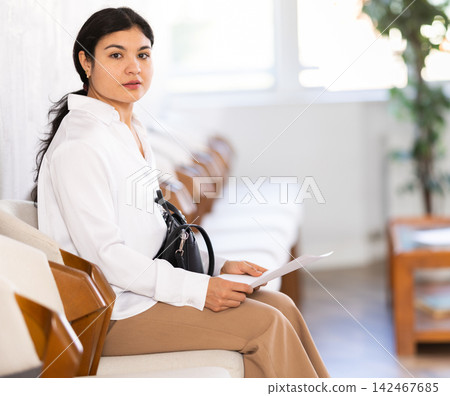 Woman sits in waiting room, queue awaiting Woman sits in waiting room, queue awaiting 142467685