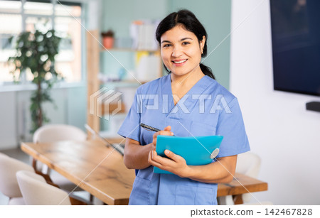 Doctor woman with document stands in office space Doctor woman with document stands in office space 142467828