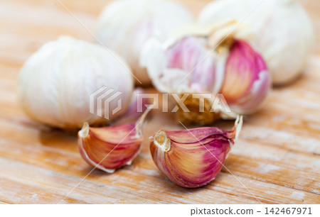 Cutting board with fresh seasonings on a wooden background. White garlic heads Cutting board with fresh seasonings on a wooden background. White garlic heads 142467971