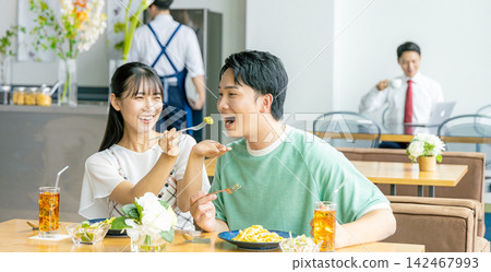 A young man and woman eating at a cafe 142467993