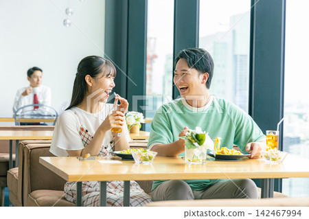 A young man and woman eating at a cafe A young man and woman eating at a cafe 142467994