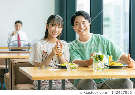 A young man and woman eating at a cafe A young man and woman eating at a cafe 142467996
