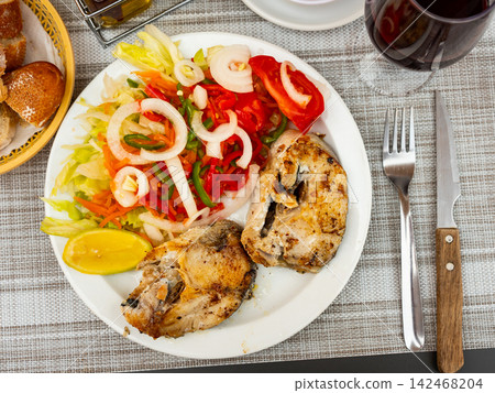 Healthy vegetarian dinner of baked hake steaks with vegetables salad and slice of lemon Healthy vegetarian dinner of baked hake steaks with vegetables salad and slice of lemon 142468204