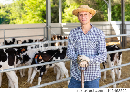Male farmer posing at cowshed on farm Male farmer posing at cowshed on farm 142468221