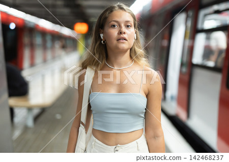 Young girl standing in platform with wireless headphones on airs 142468237
