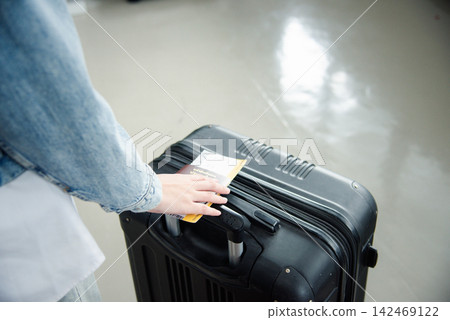 Close up hands woman tourist going to flight with suitcase holding Thailand passport and airline ticket on baggage Close up hands woman tourist going to flight with suitcase holding Thailand passport and airline ticket on baggage 142469122