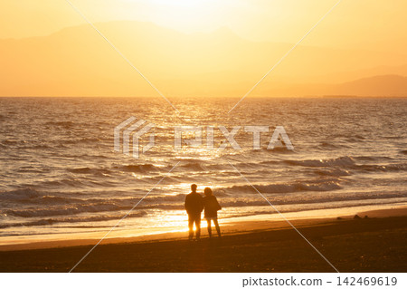 湘南久沼海灘:夕陽照亮了大海和人們的剪影。 湘南久沼海灘:夕陽照亮了大海和人們的剪影。 142469619
