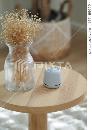 Small speaker and vase on a wooden table Small speaker and vase on a wooden table 142469669