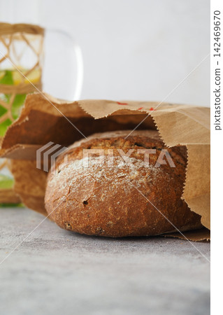 Bread in a brown bag on a gray surface Bread in a brown bag on a gray surface 142469670
